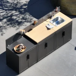 Cozinha exterior com 3 módulos em aço e decoração em madeira