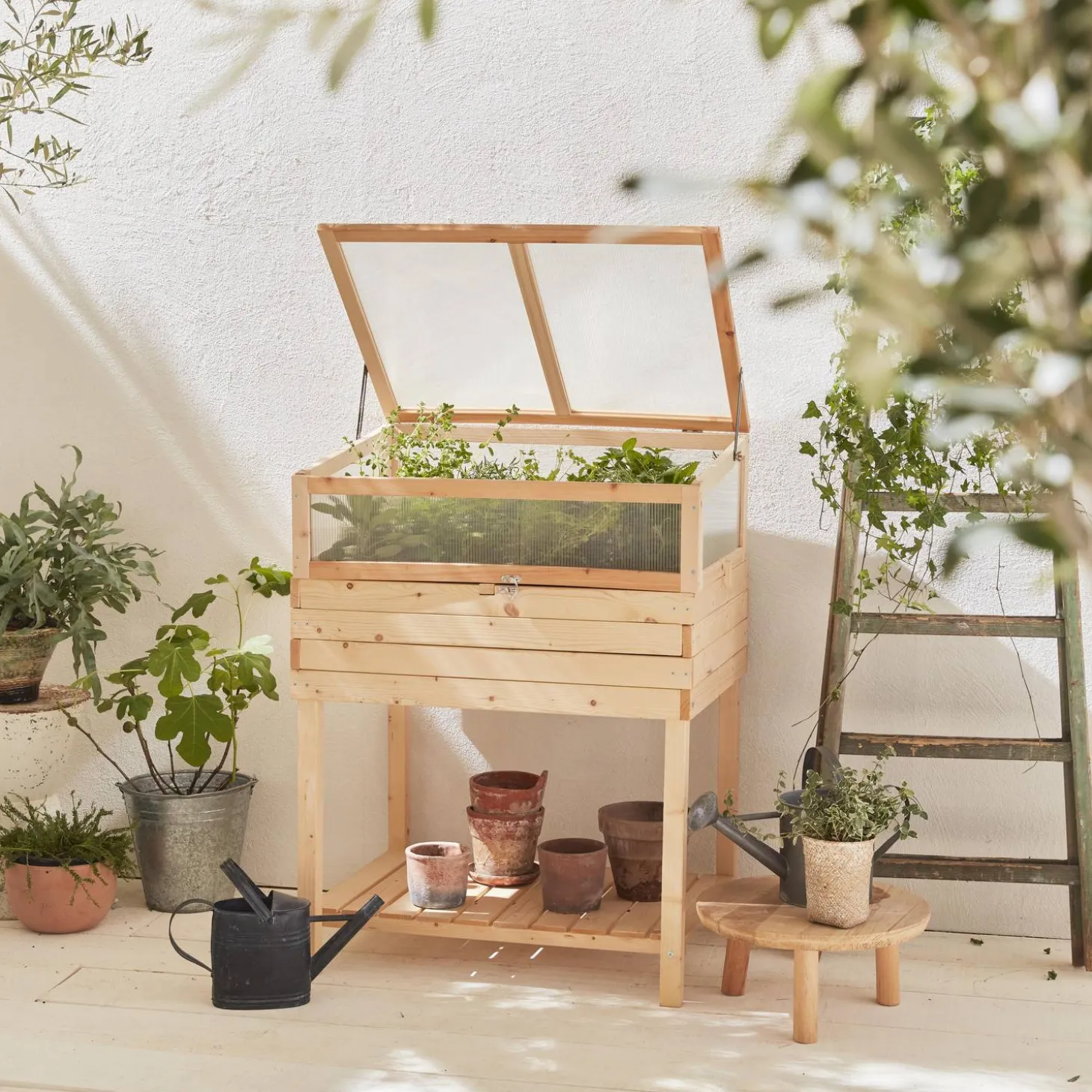 Horta quadrada com pés de madeira e estufa